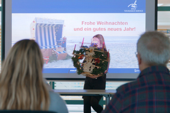 Eine Frau hält einen Weihachtskranz