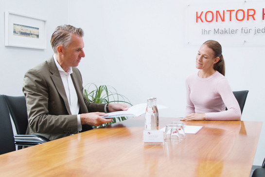 bb_kjko_teaser_06.jpg Konto Kjer Geschäftsführer überreich Unterlagen an eine Kundin