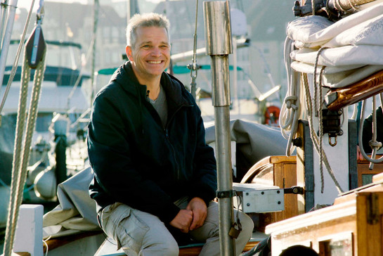 Ein lächelnder Mann sitzt auf einem Boot