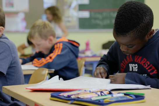 Ein Kind schreibt im Unterricht