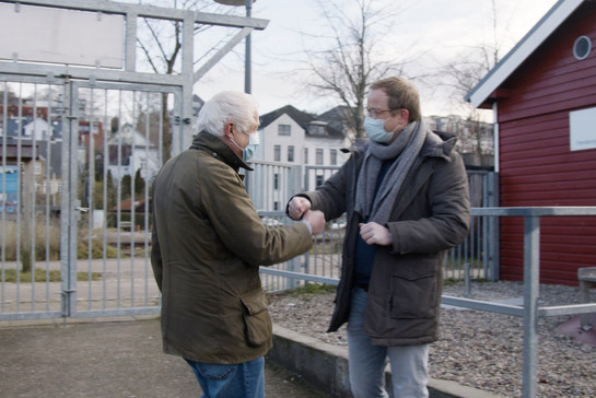 Maximilian Bruhn begrüßt einen Mann am Flensburger Hafen