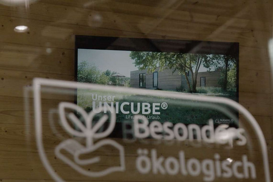 "Unser Unicube" auf Display hinter "Besonders ökologisch"-Award bb_mehu_teaser_04.jpg