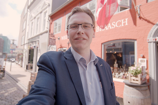 bb_nachbarschaftlichegruesse_teaser_04.jpg Selfie eines Mannes in der roten straße