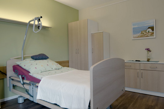 Ein leeres Krankenhausbett mit individueller Bettwäsche.