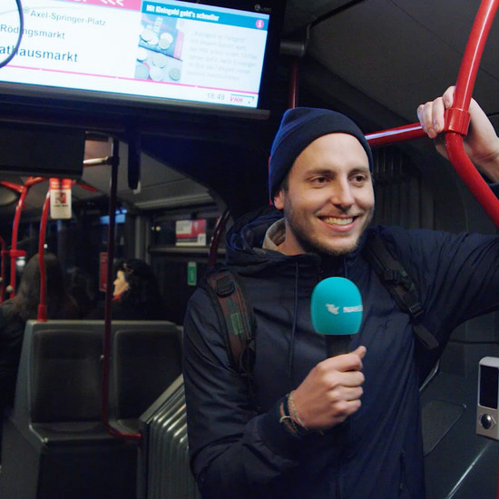 Ein Mann mit Mikrofon fährt Abends Bus