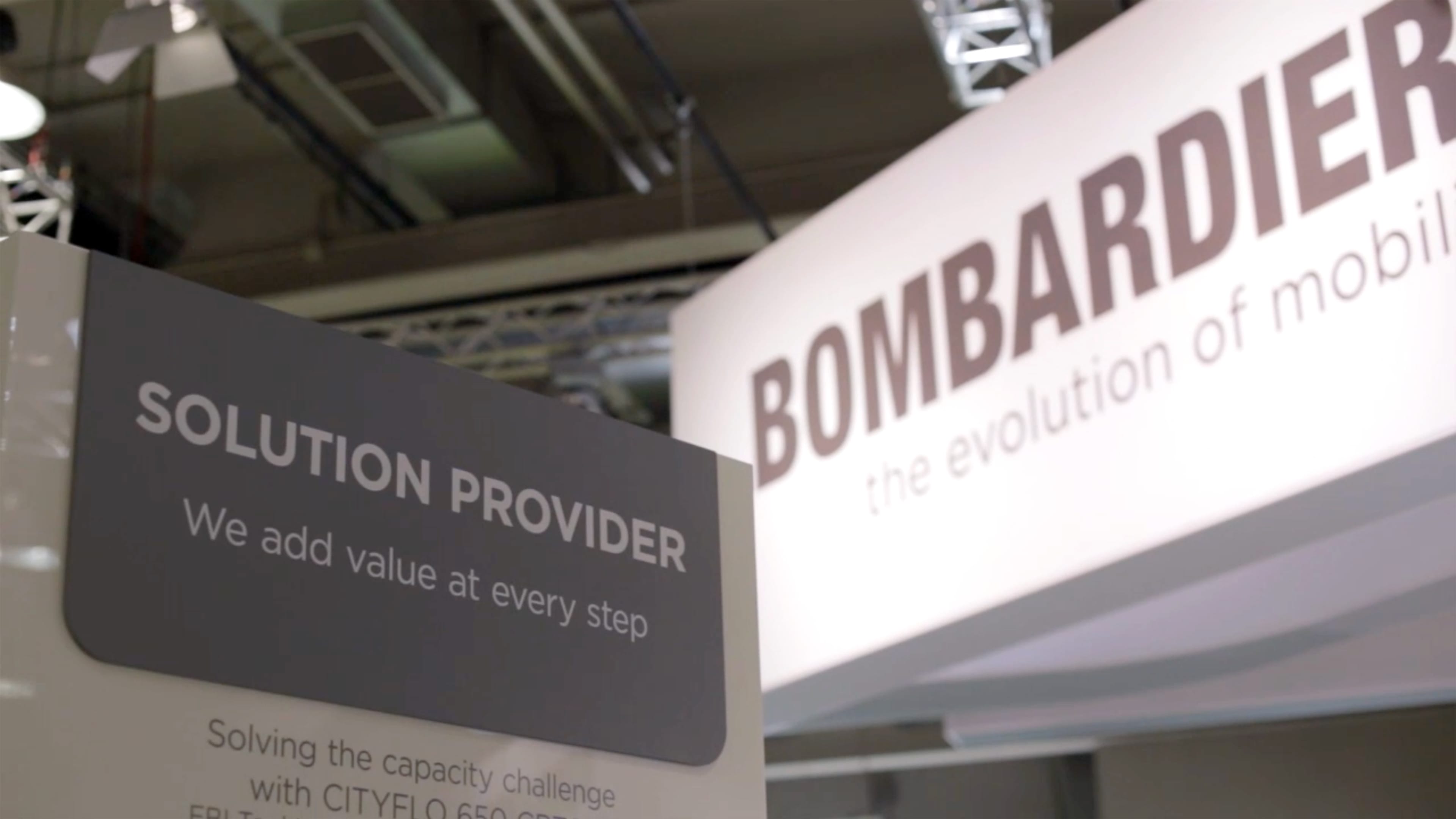 Ein Schild mit englischer Aufschrift, im Hintergrund steht „Bombardier“.