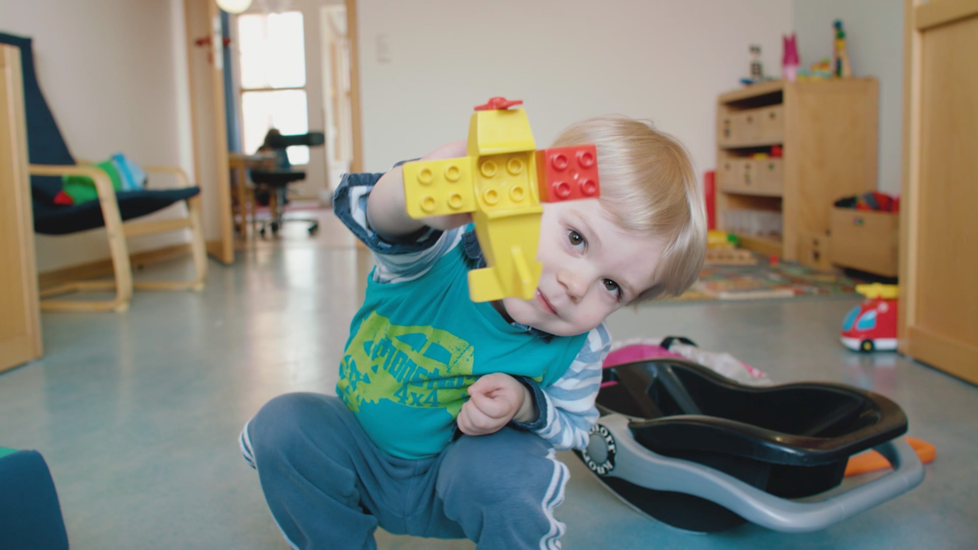 Ein Kind hält einen Lego Baustein in die Kamera