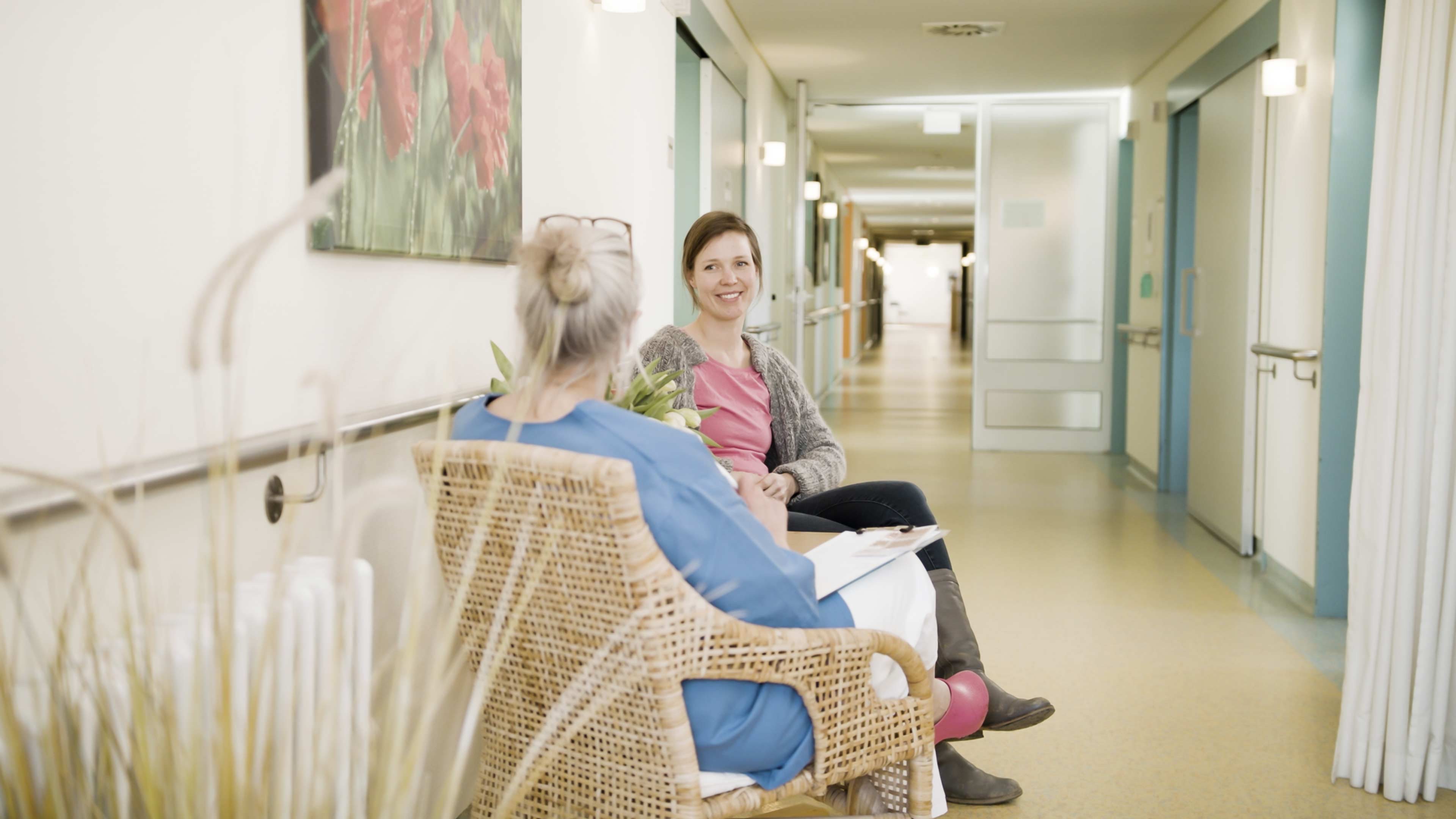 Zwei Frauen sitzen im krankenhausflur