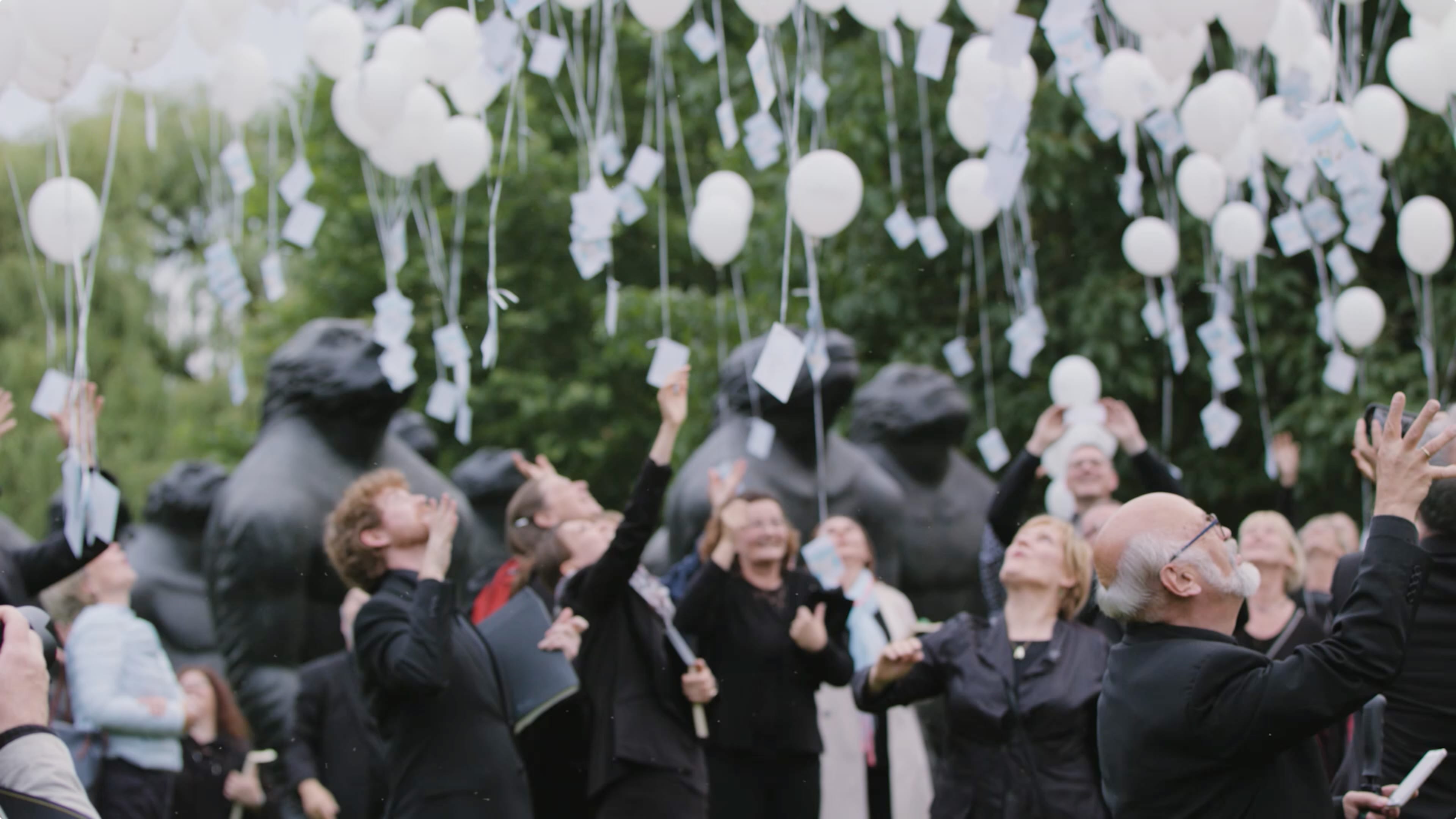 Eine Menschengruppe lässt Ballons steigen