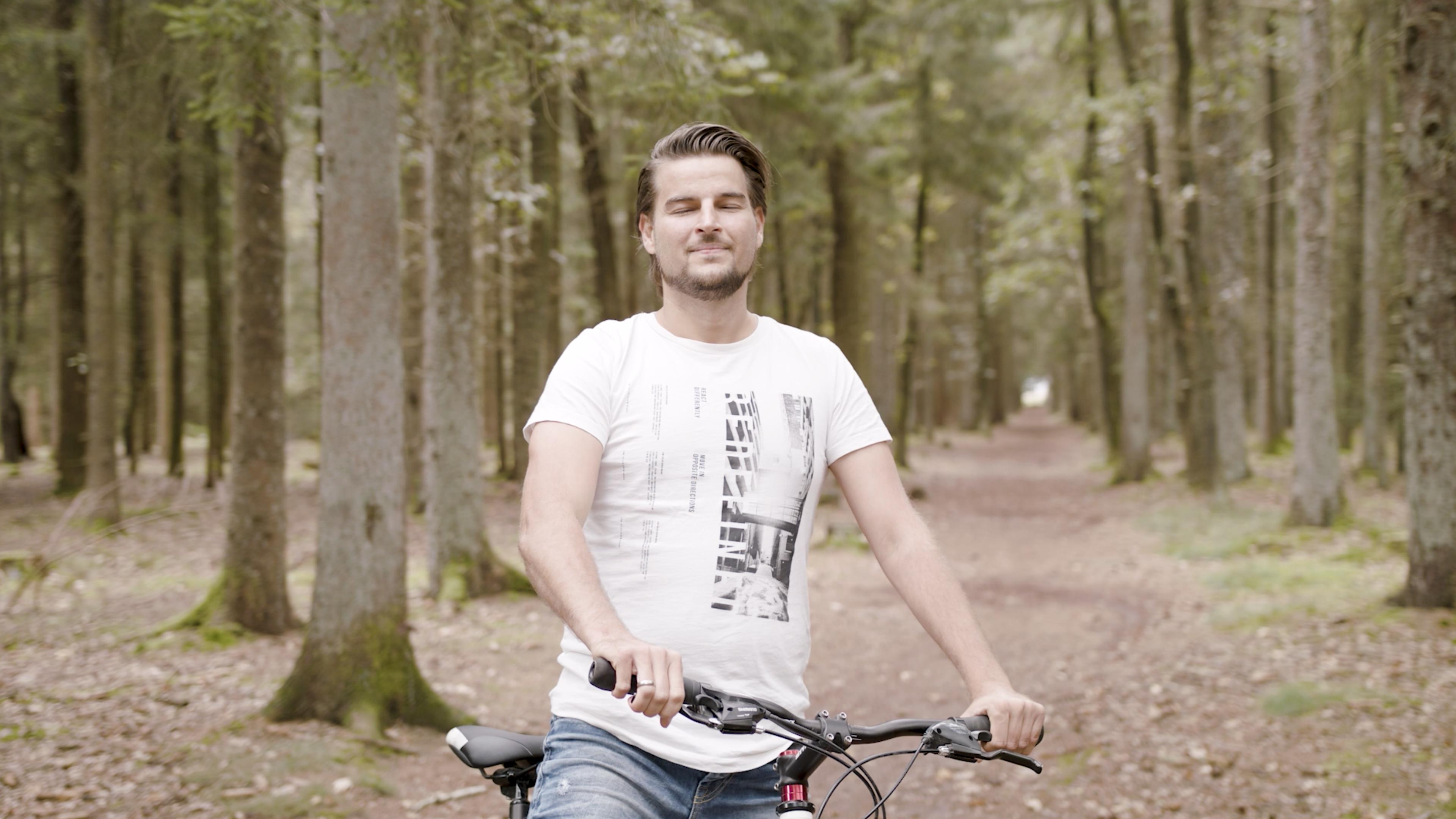 Mann mit Fahrrad im Wald