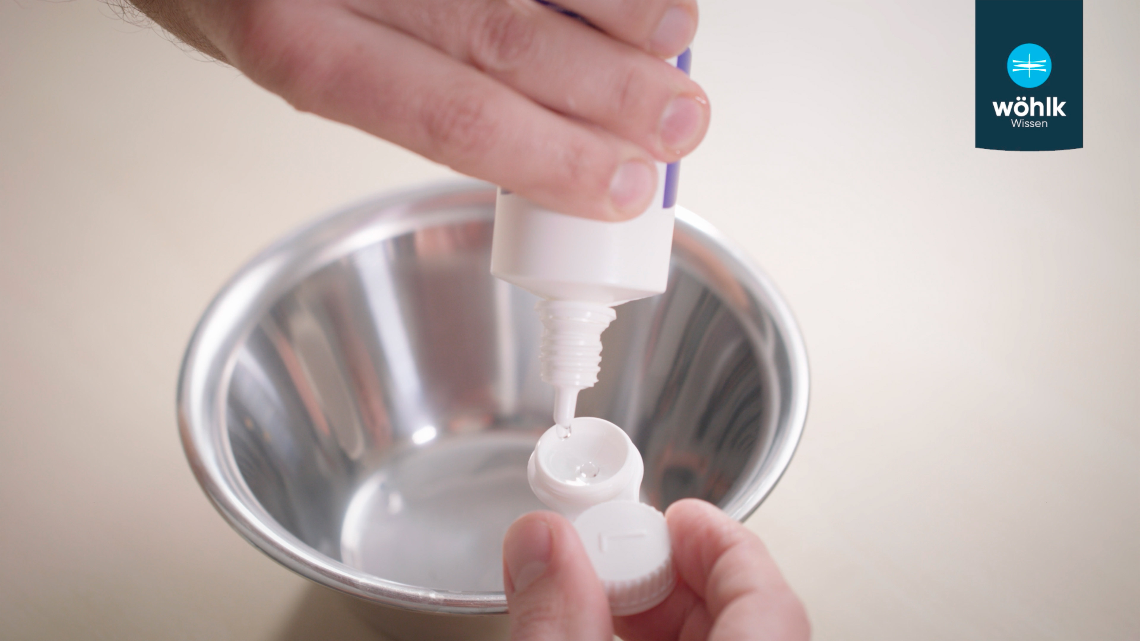 Eine Person befüllt eine Kontaktlinsenpackung mit Wasser