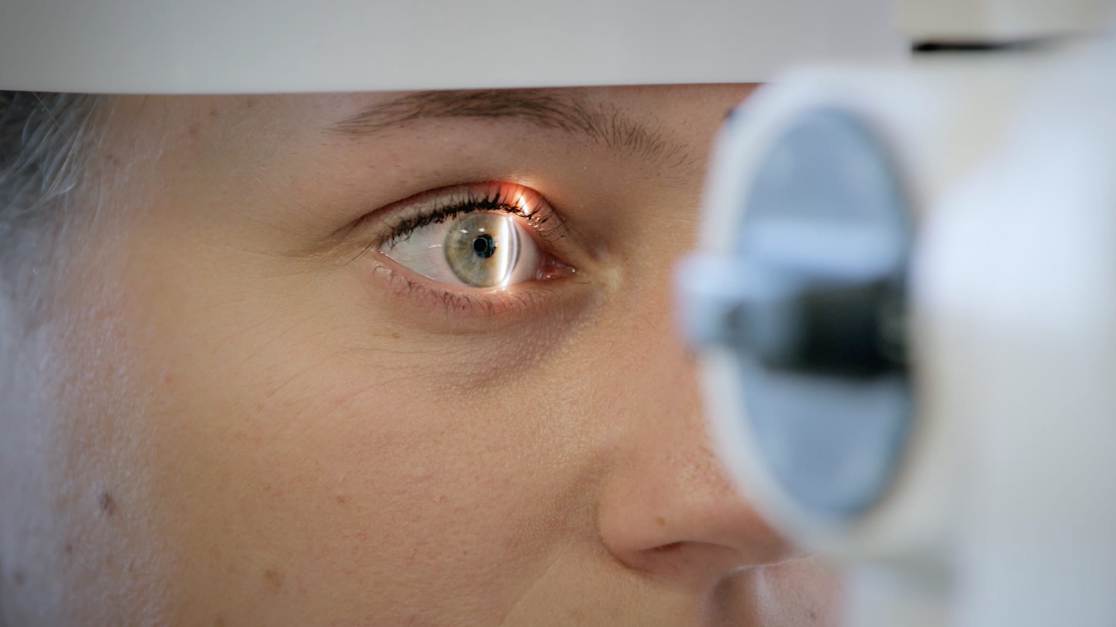 Eine Frau lässt ihr Auge beim Optiker untersuchen