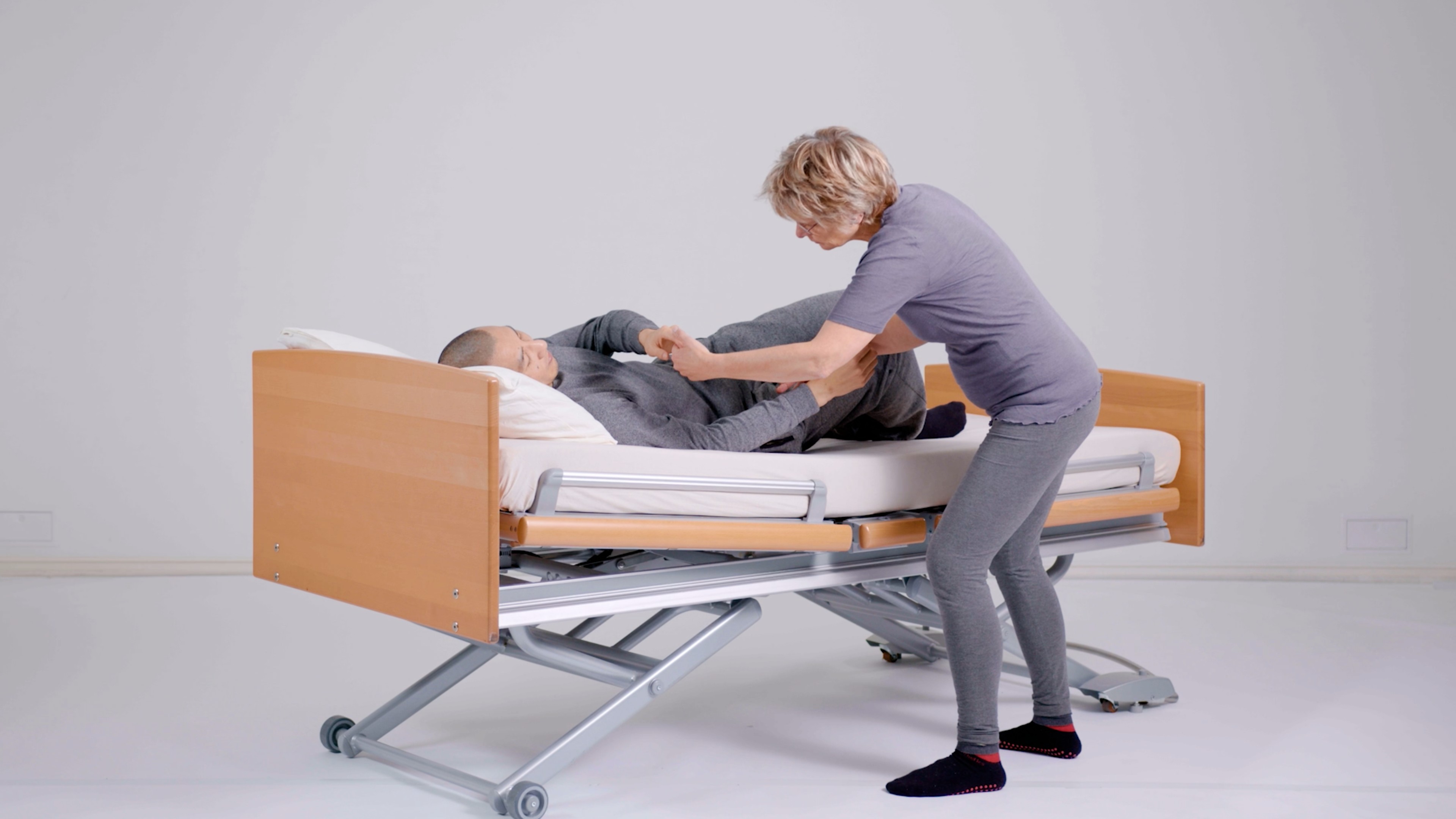 Eine Pflegerin von Kinaesthetics macht Übungen mit einem Patienten